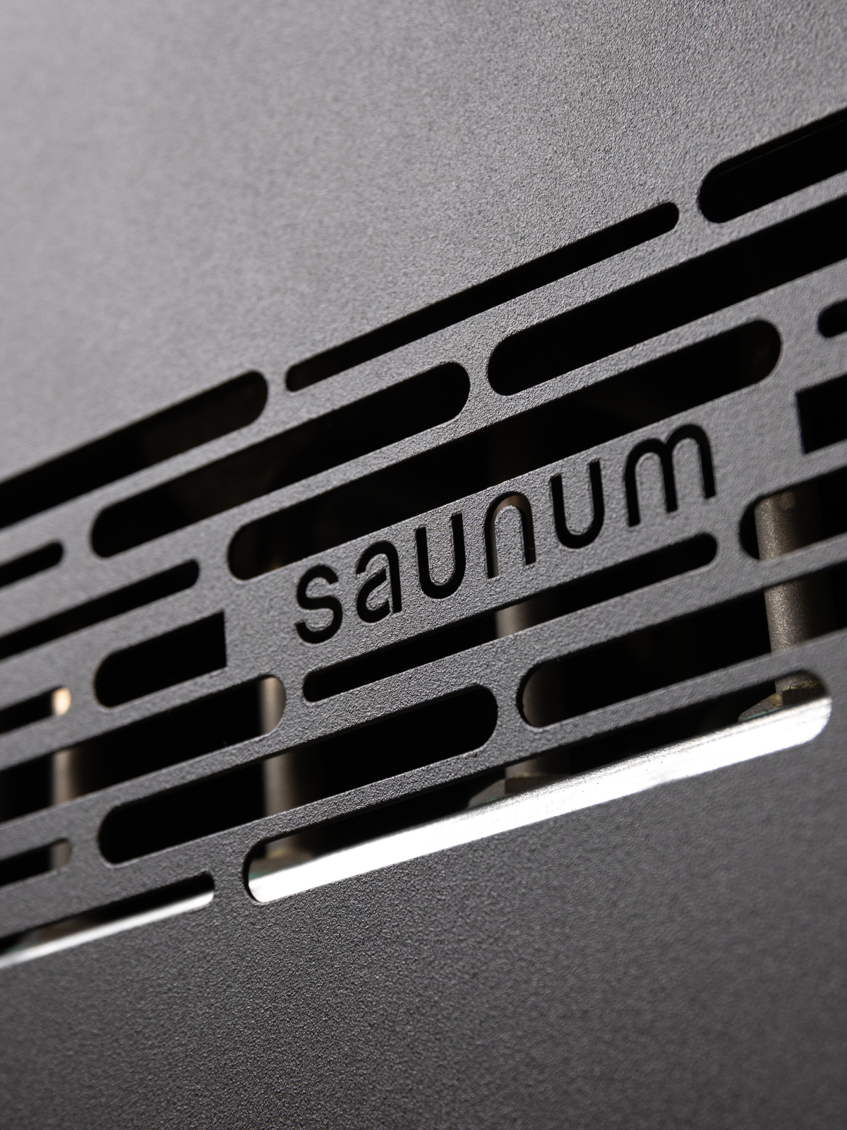 Close-up of a metallic surface with 'saunum' branding.