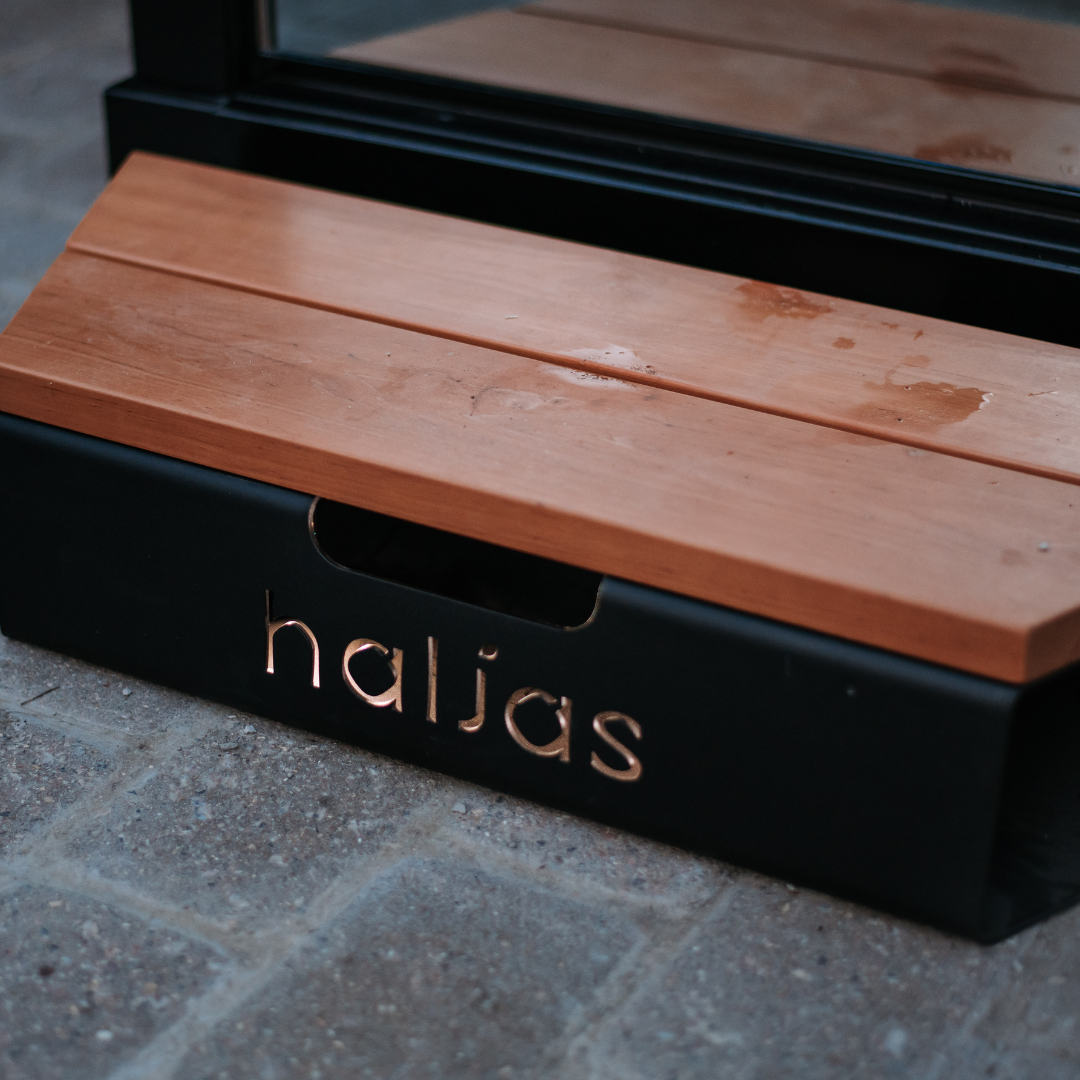Wooden lid on a black box with 'nalias' branding, placed on a stone surface.