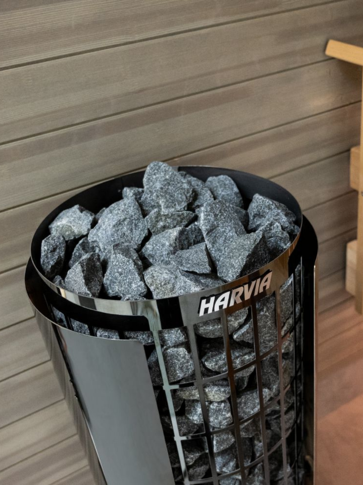 Harvia sauna heater with stones inside against a wooden wall background