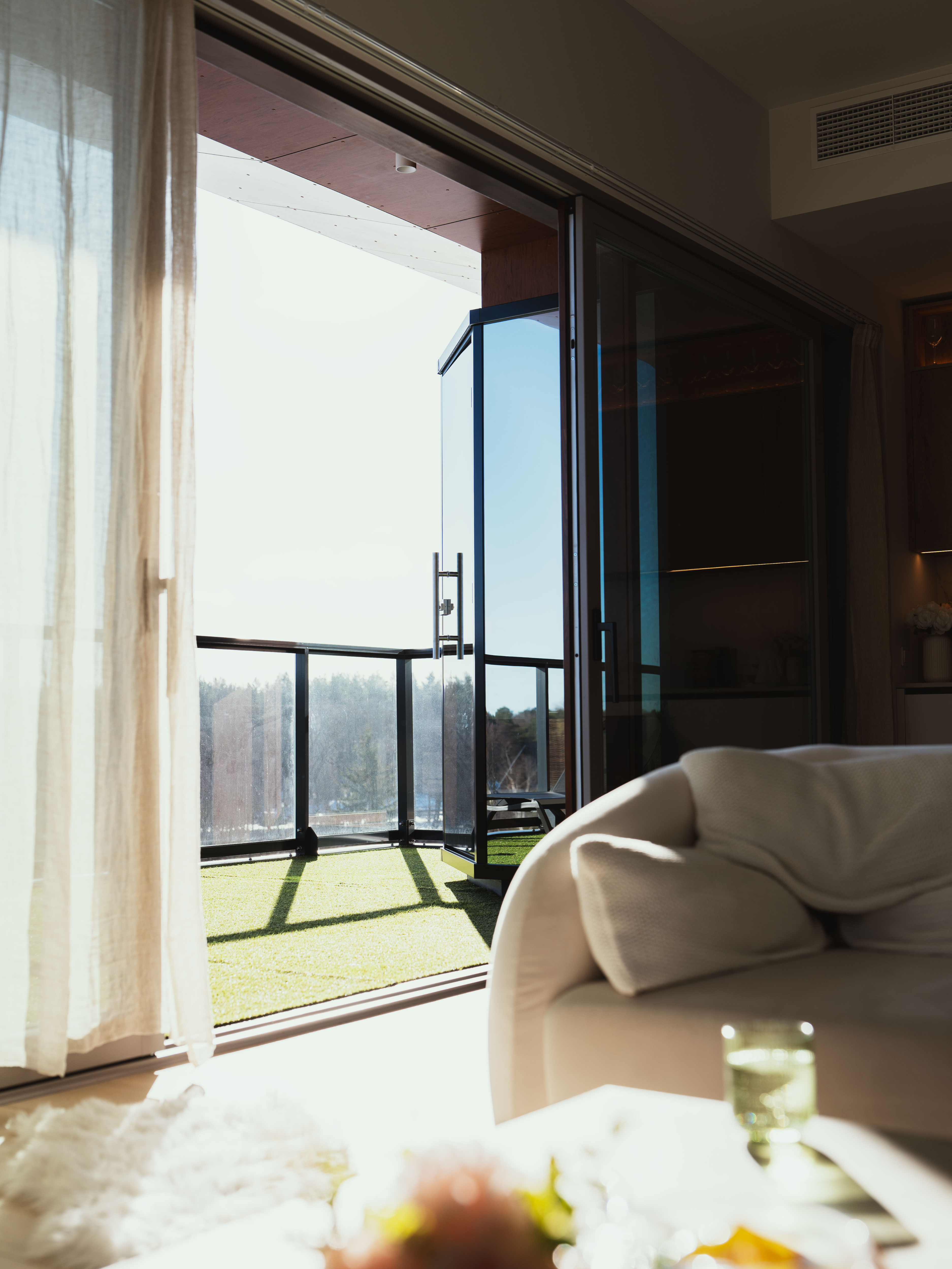 Modern living room with large glass door leading to a balcony
