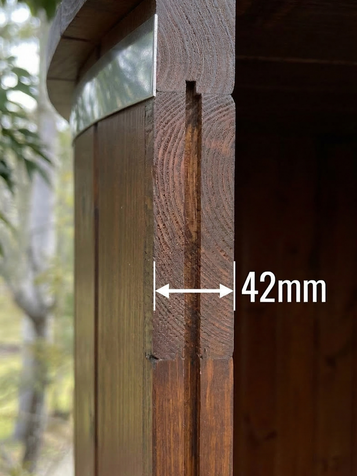 Wooden beam with a 42mm measurement label, outdoor setting