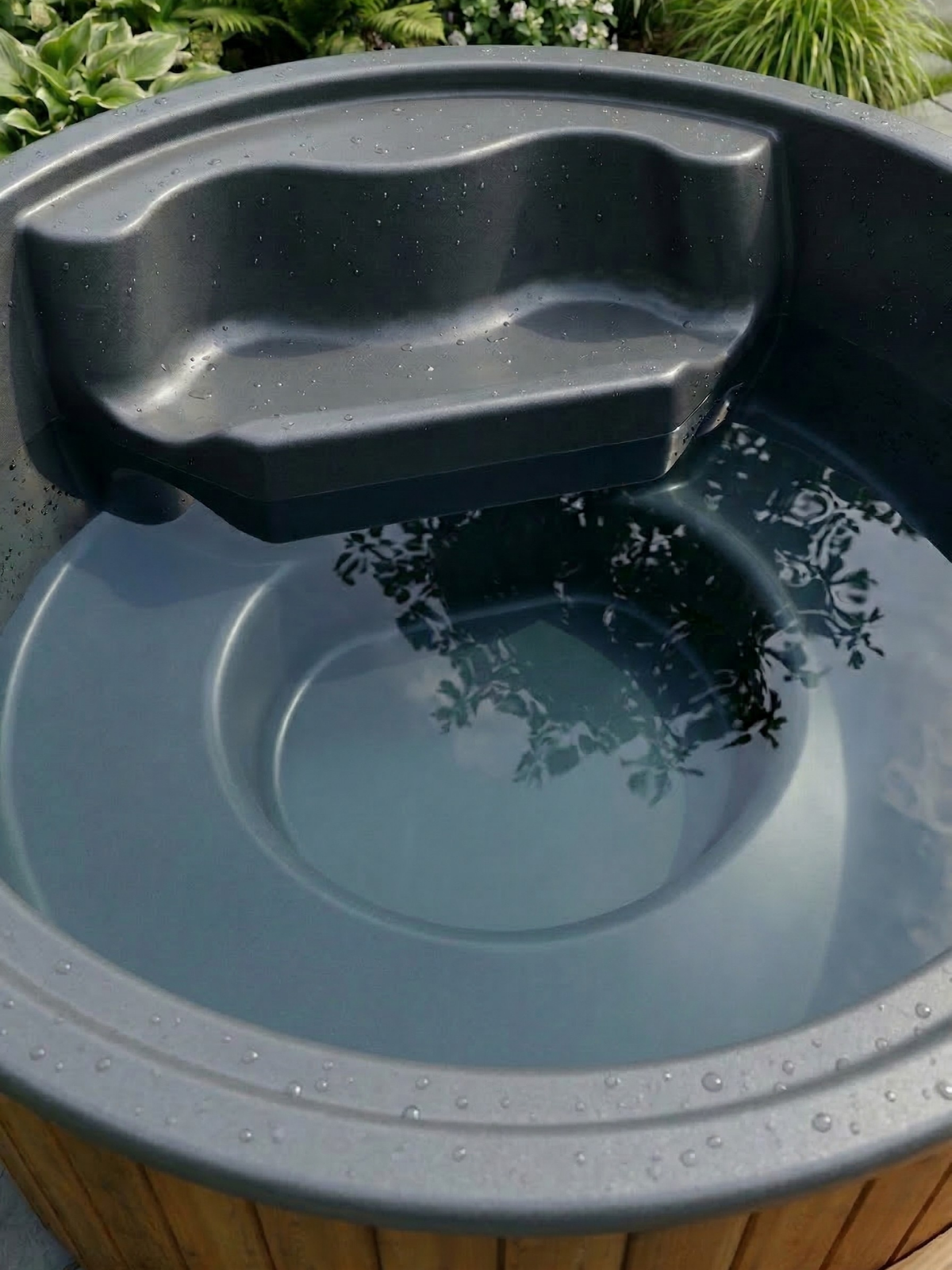Gray bird bath with water in a garden setting