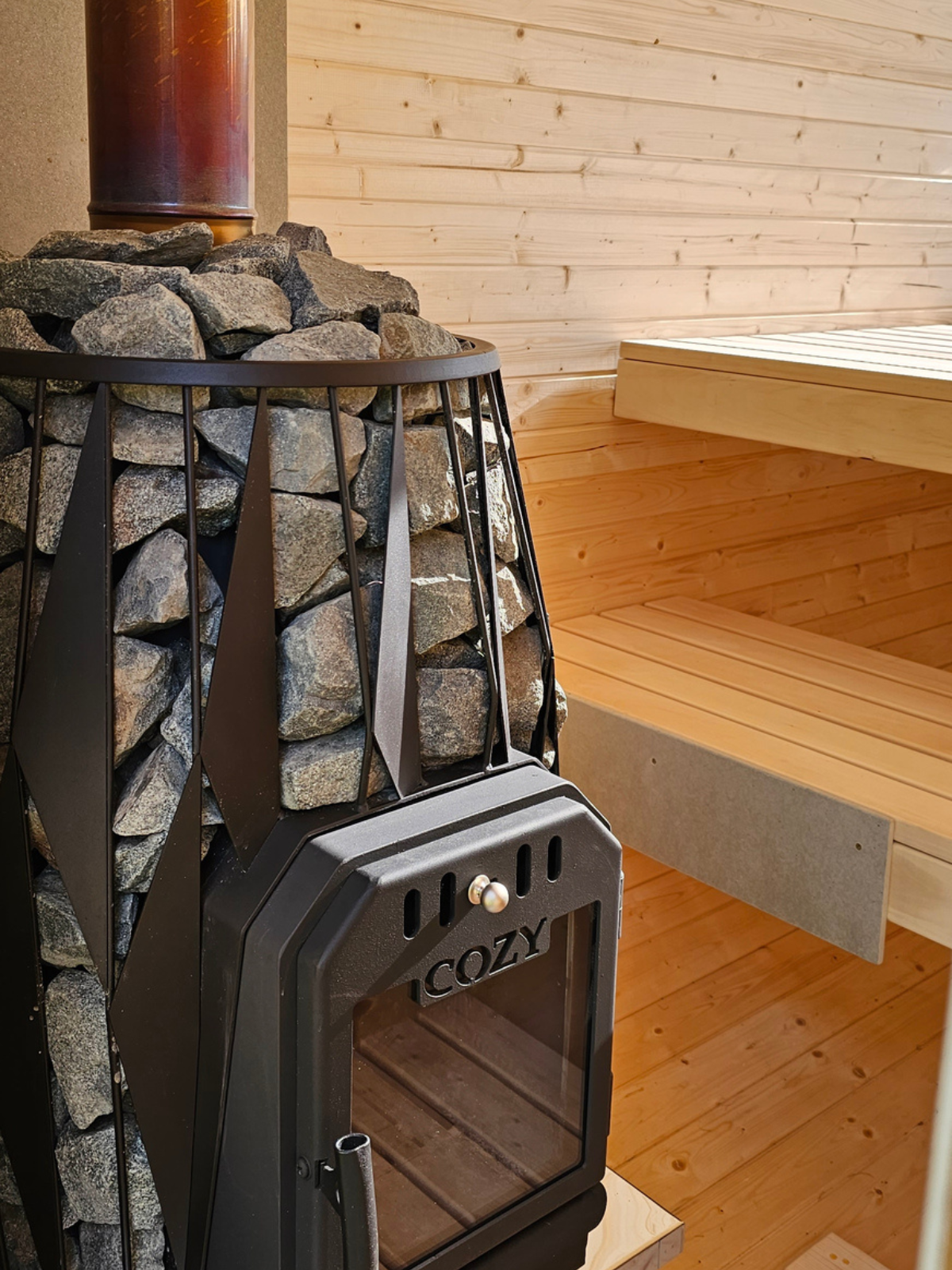 Wood-burning stove with stone interior in a wooden sauna
