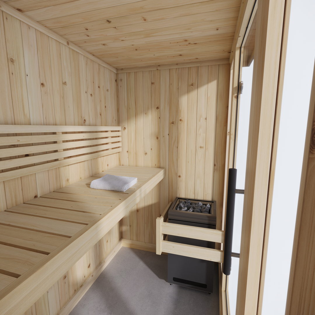 A cozy wooden sauna interior with light-toned paneling. A single bench holds a folded white towel. A heater with stones is adjacent to a glass door.
