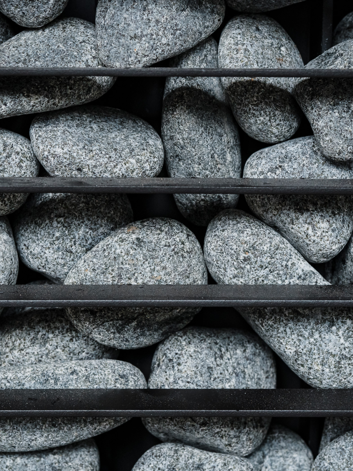 Stack of gray stones on a black metal shelf