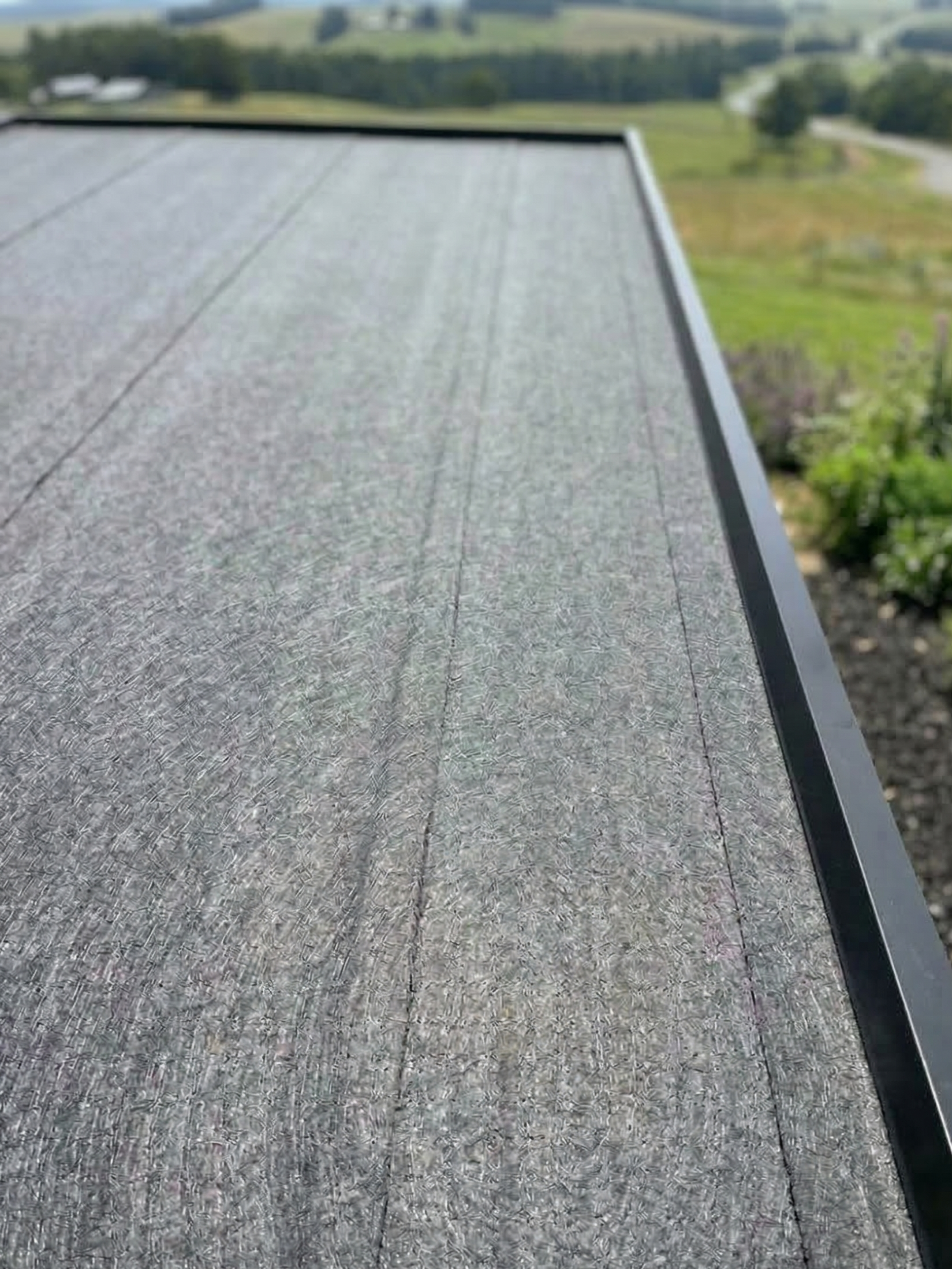 Close-up of a roof edge with a landscape in the background