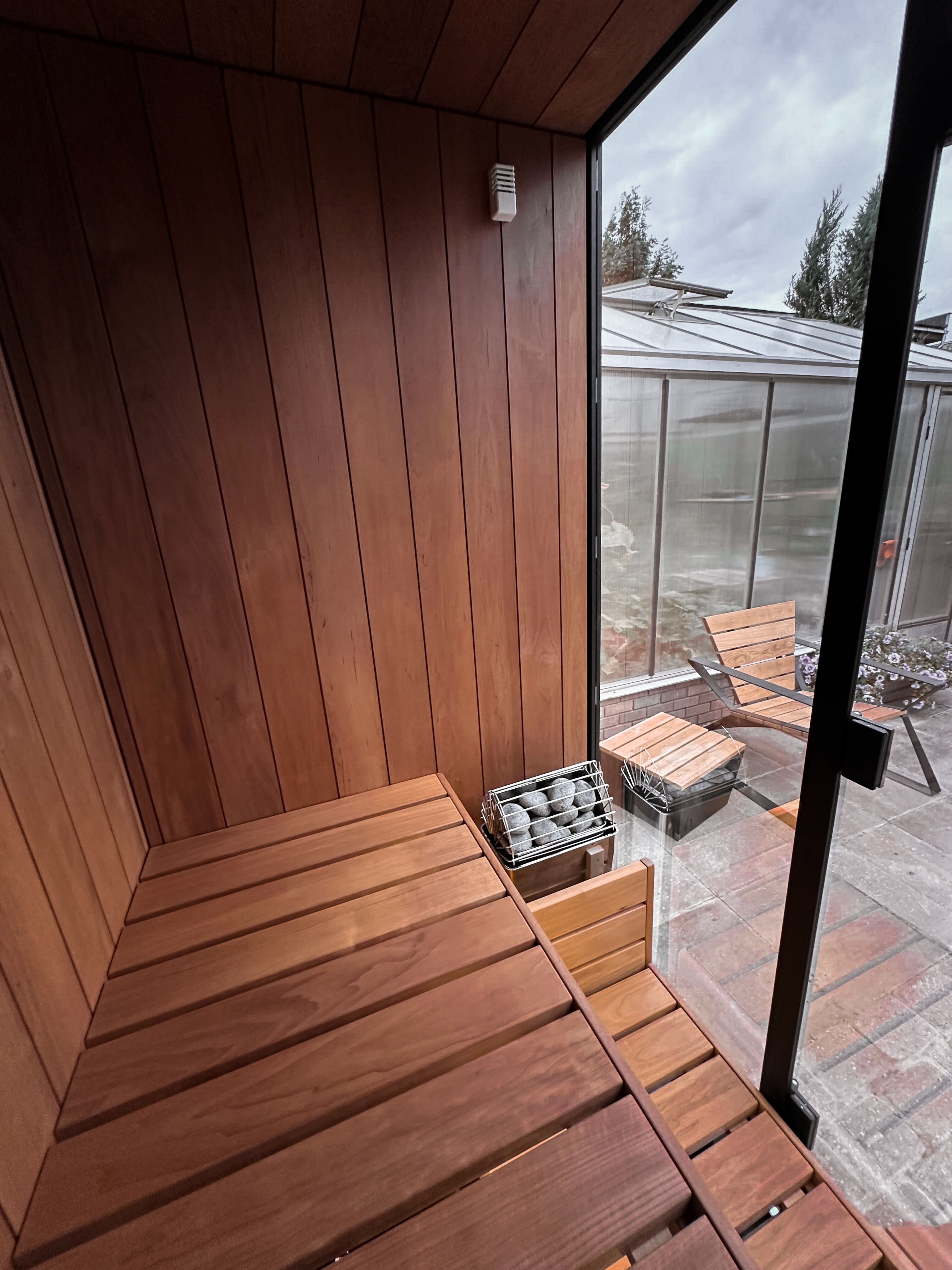 Wooden sauna with a view of a patio area outside