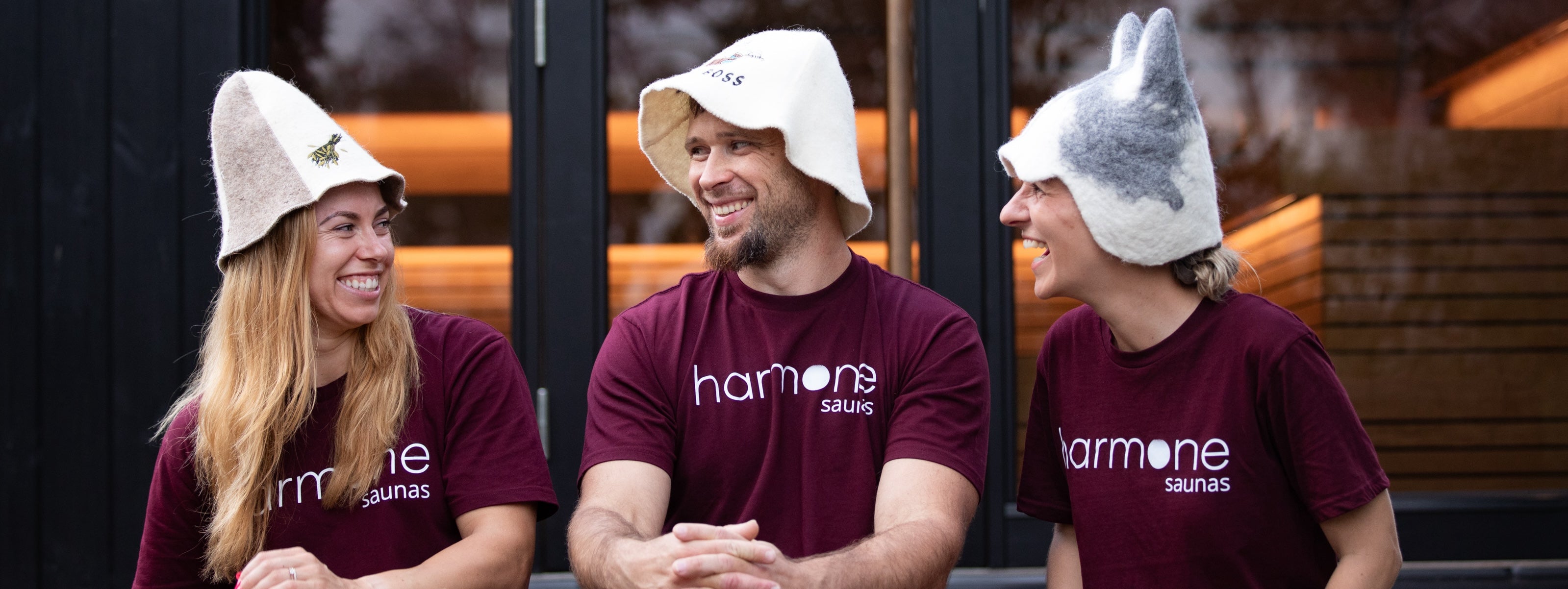 Three people wearing hats with animal ears and 'harmone' shirts in an outdoor setting.