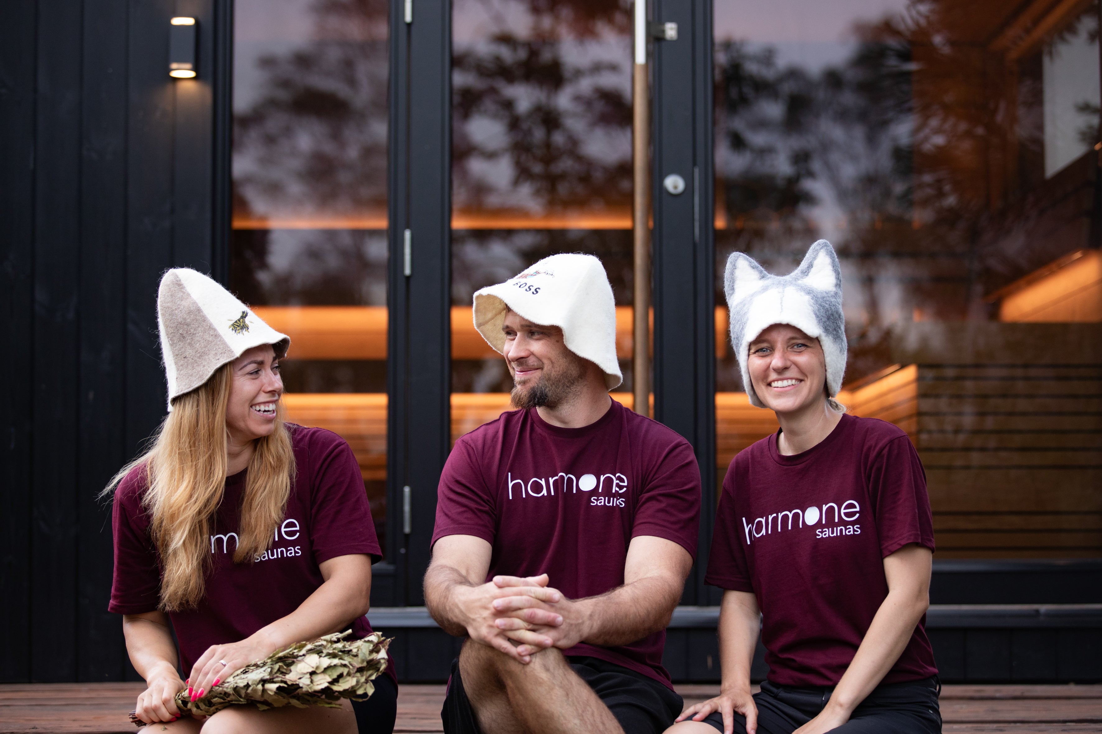 Harmone team wearing themed hats sitting together outdoors.