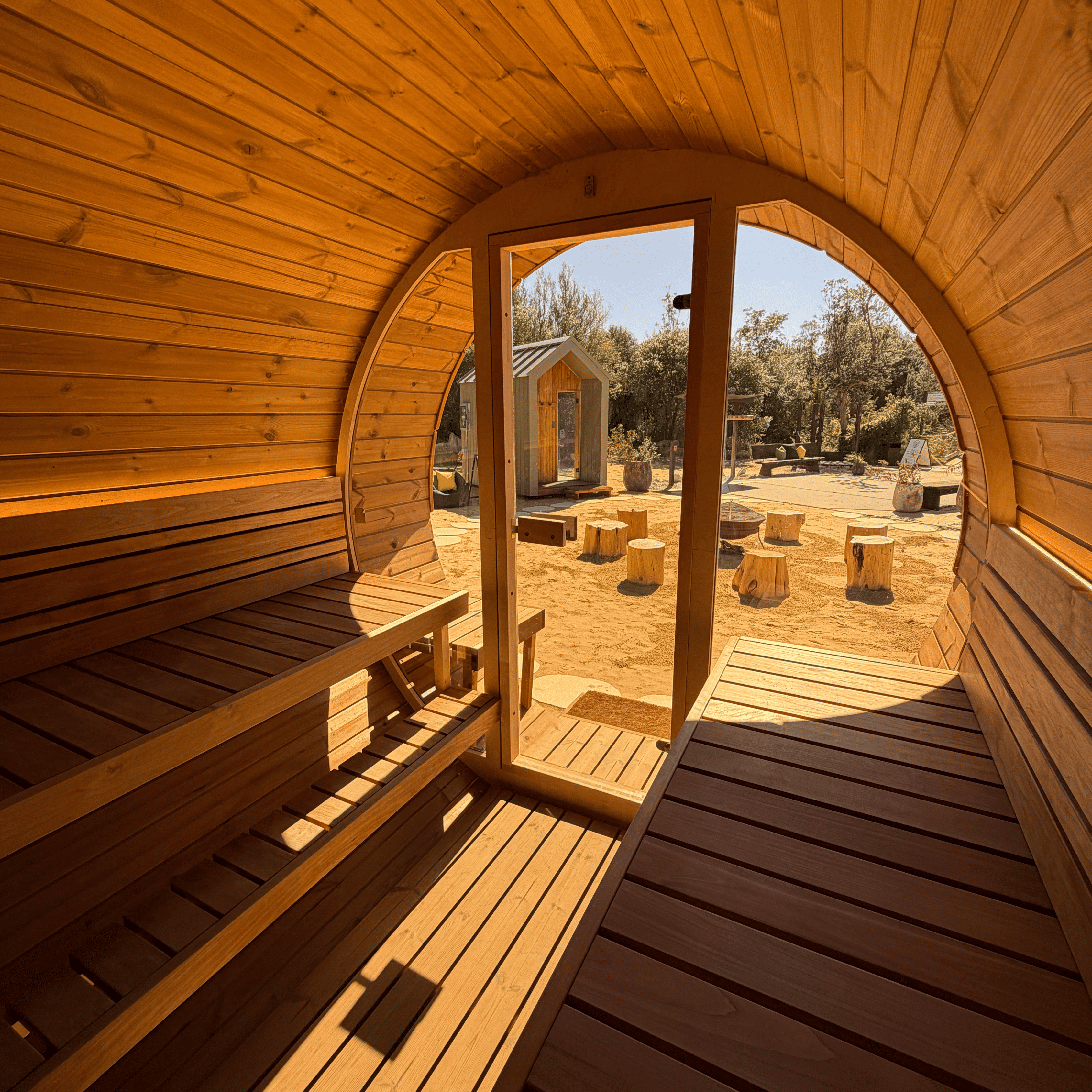 Wooden sauna with open door showing outdoor setting