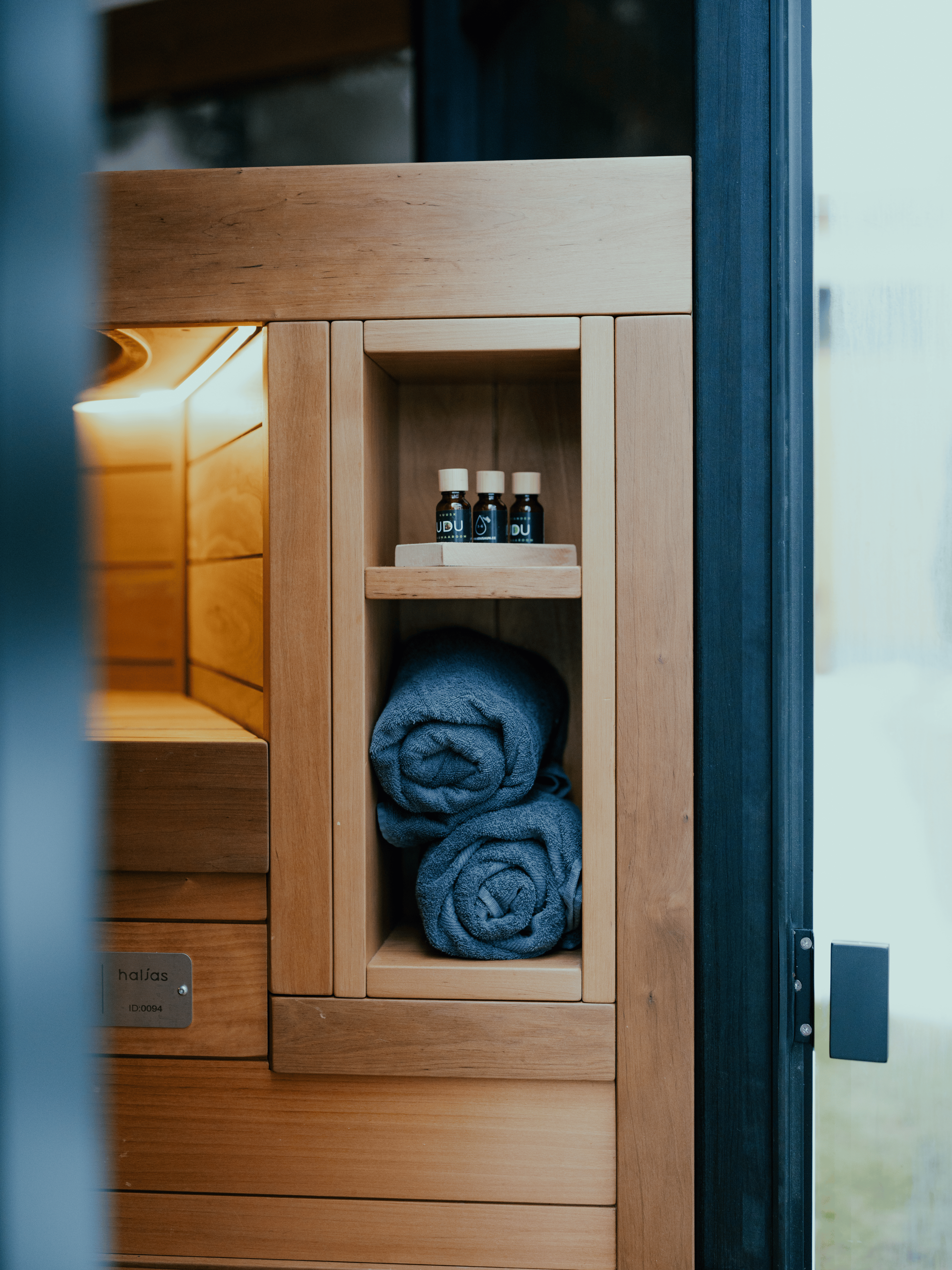 Wooden cabinet with towels and bottles inside