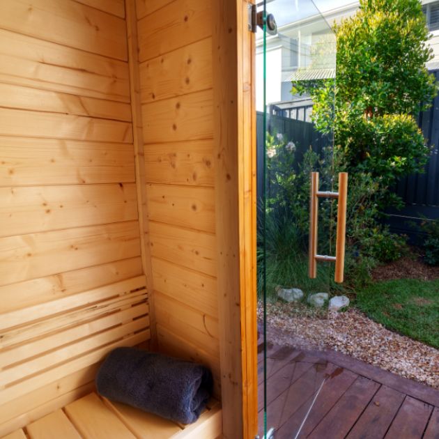 Wooden shed with glass door open, showing a garden view