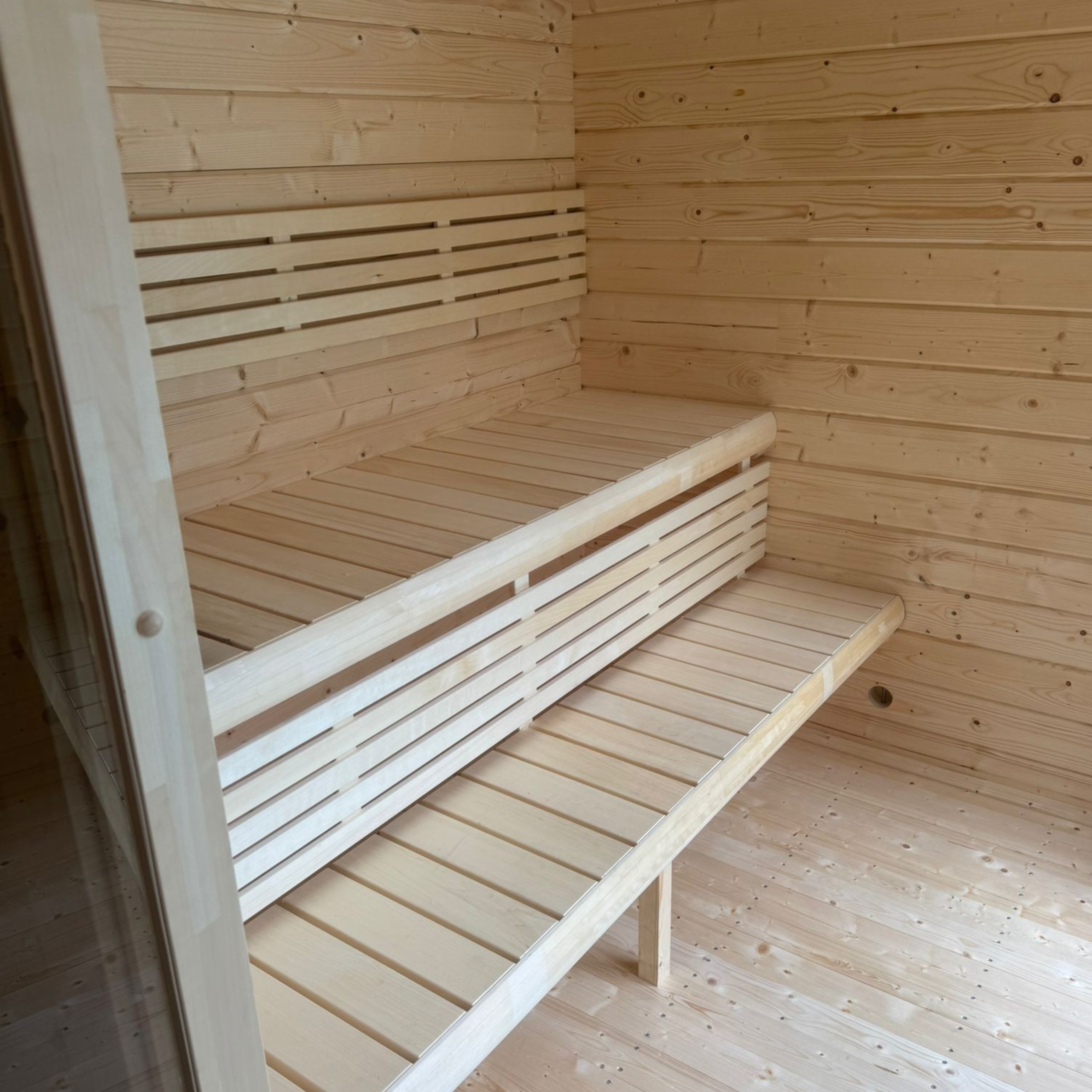 Wooden sauna with bench and slatted walls