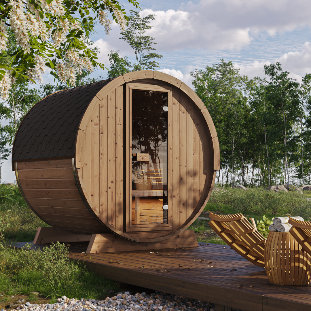A barrel-shaped outdoor sauna made of wood, with a large glass door and a bench inside, set in a natural outdoor setting.