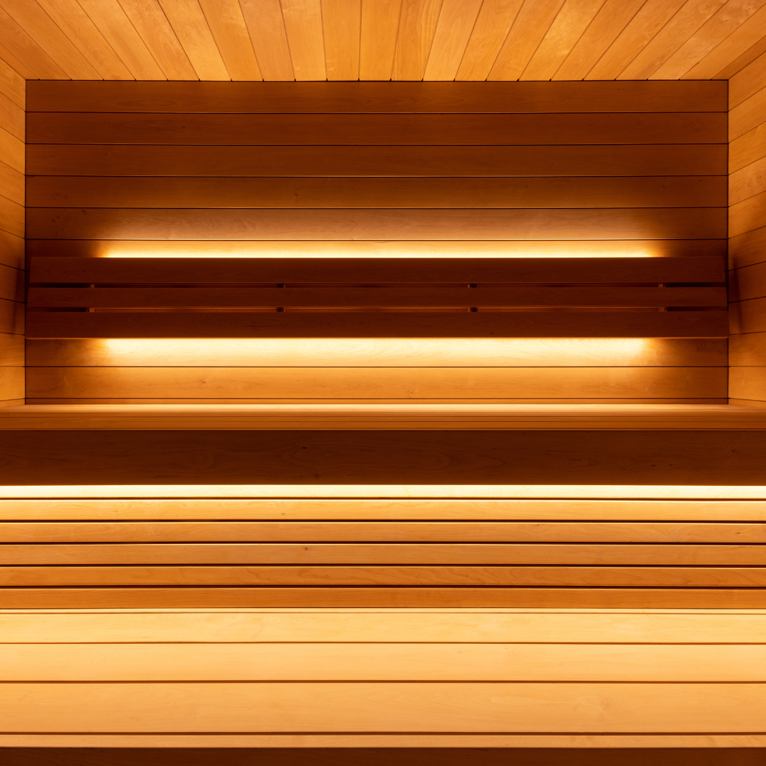 Wooden sauna interior with horizontal slats and embedded lights.