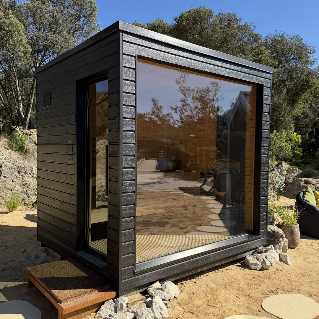 Modern outdoor cabin with reflective glass walls in a natural setting