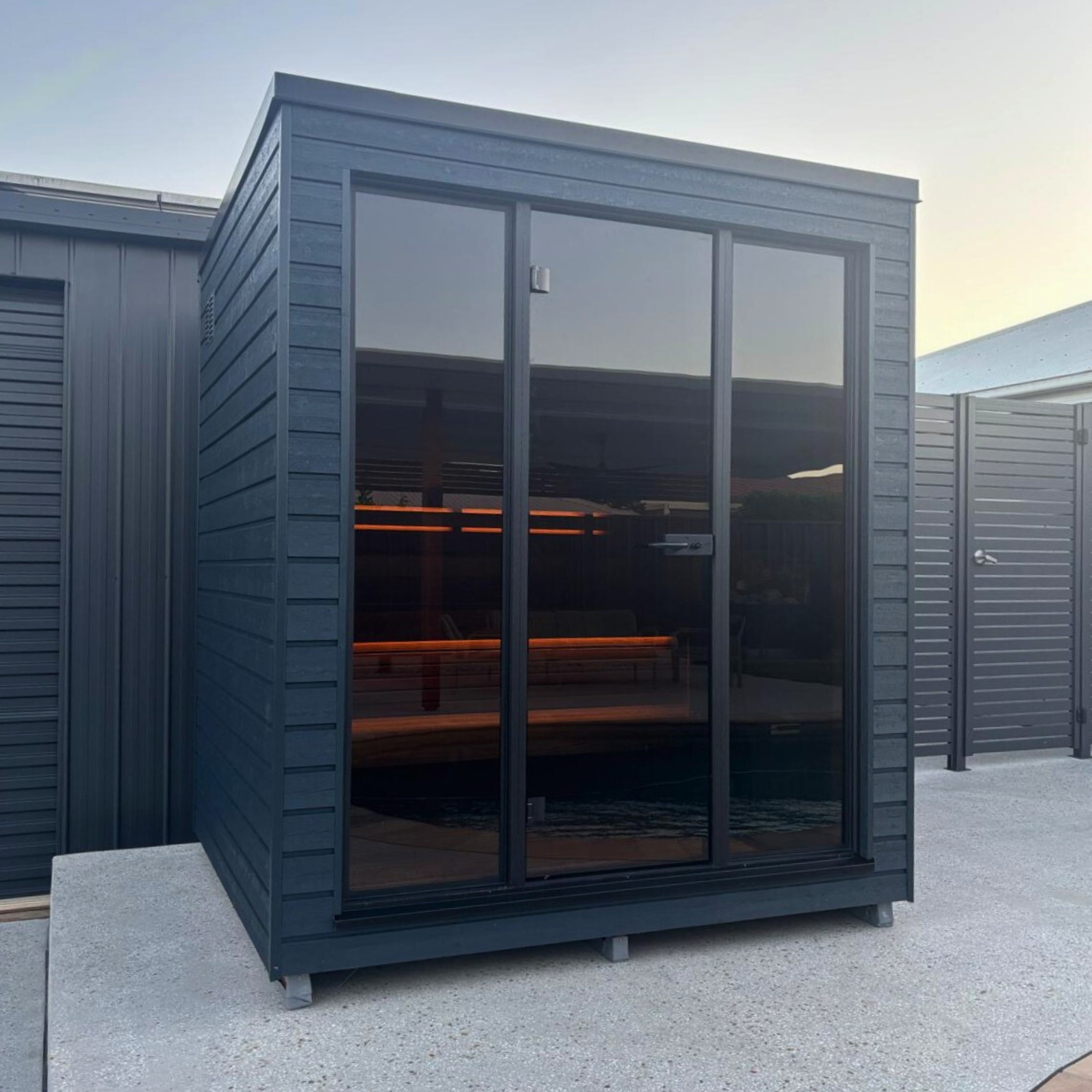 Modern garden office with large glass windows on a clear day