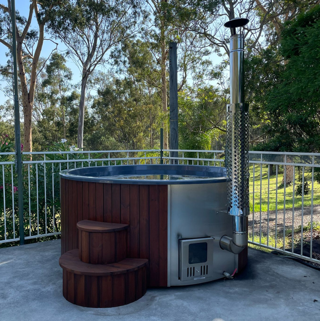 Hot tub with a patio heater on a concrete deck surrounded by trees