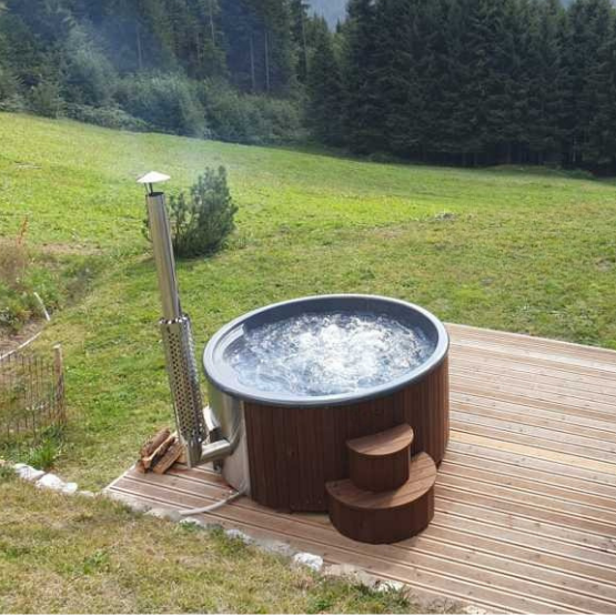 Hot tub on a wooden deck with a forest background
