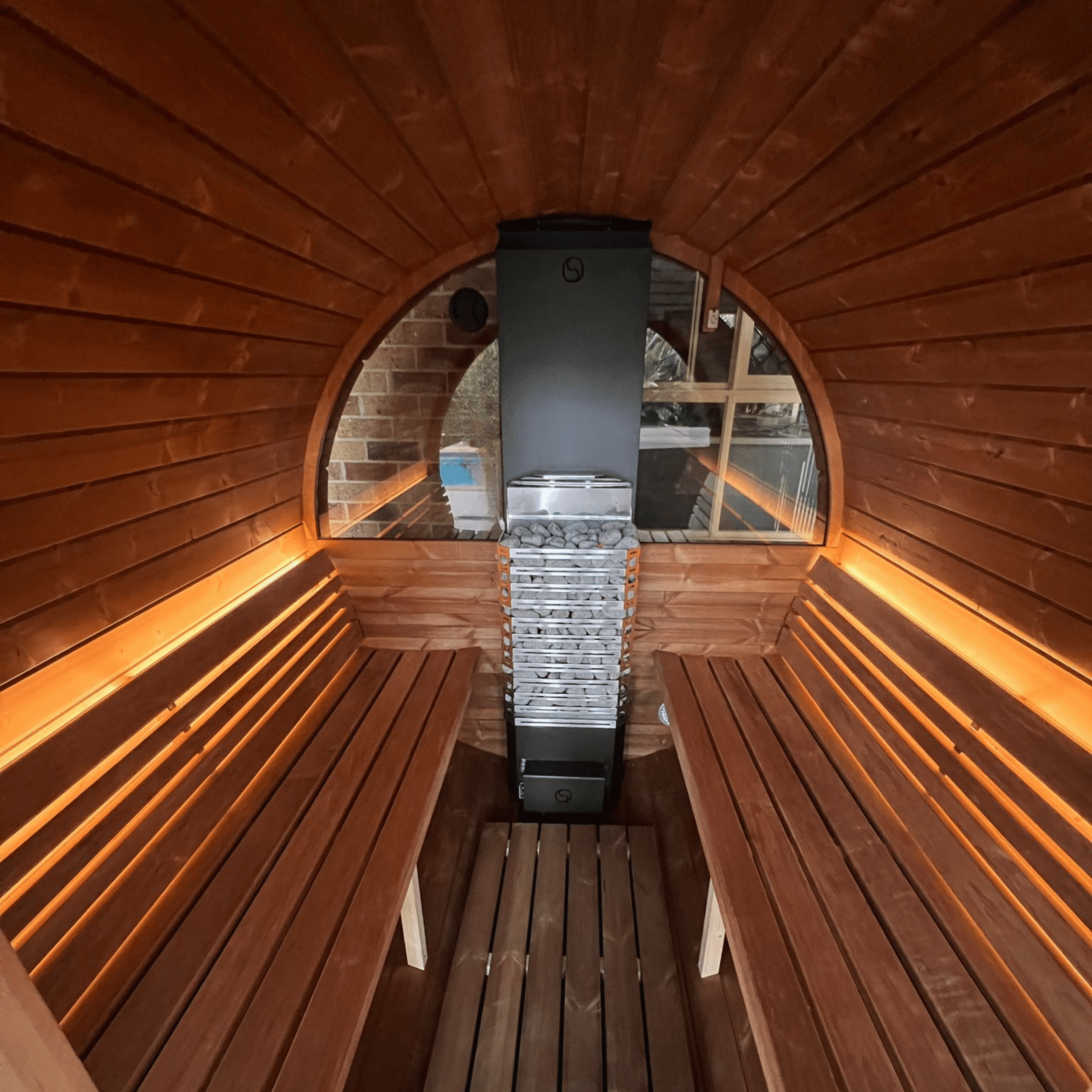 Wooden sauna interior with benches and a stove.