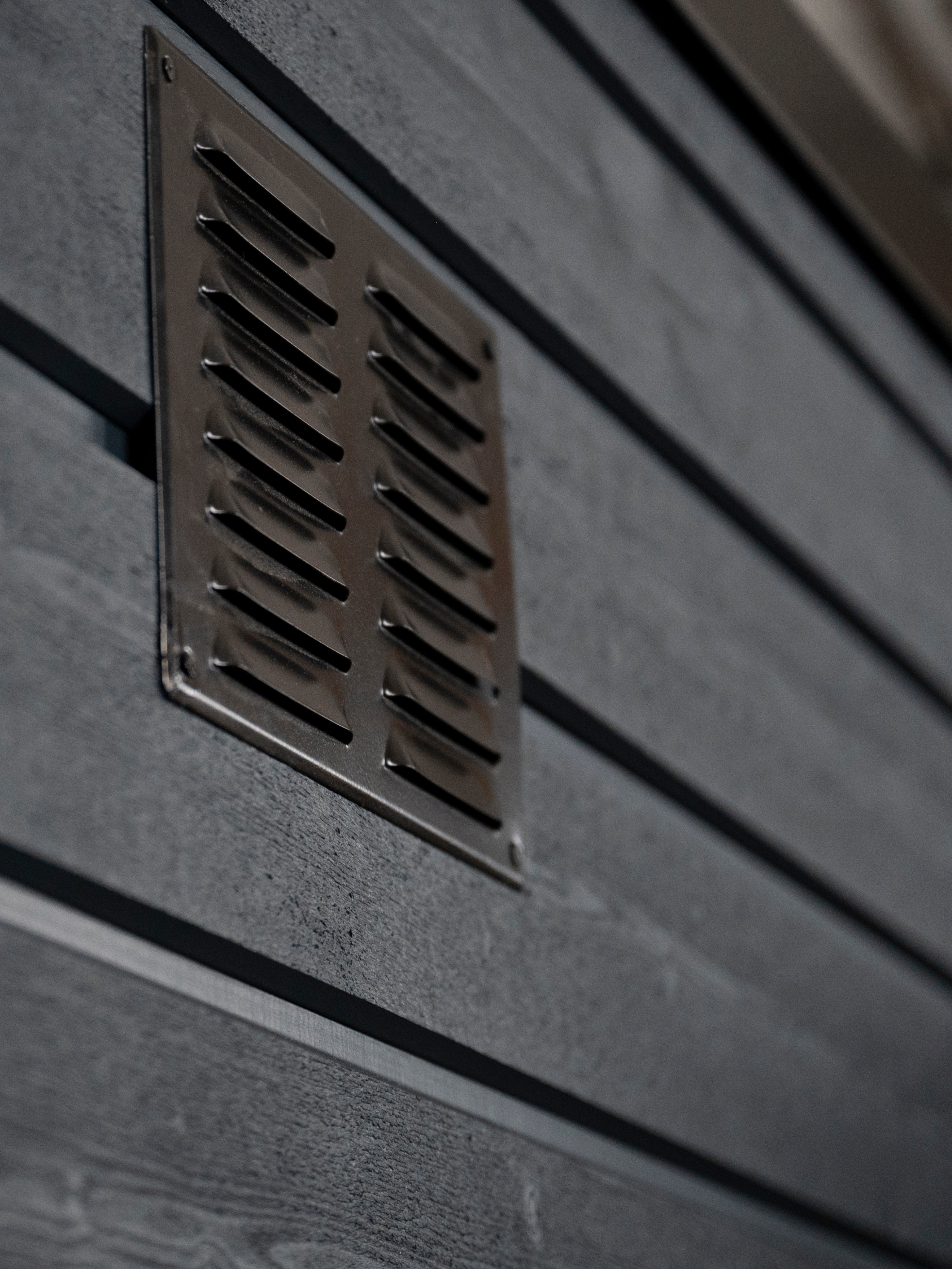 Metallic vent on a textured wall