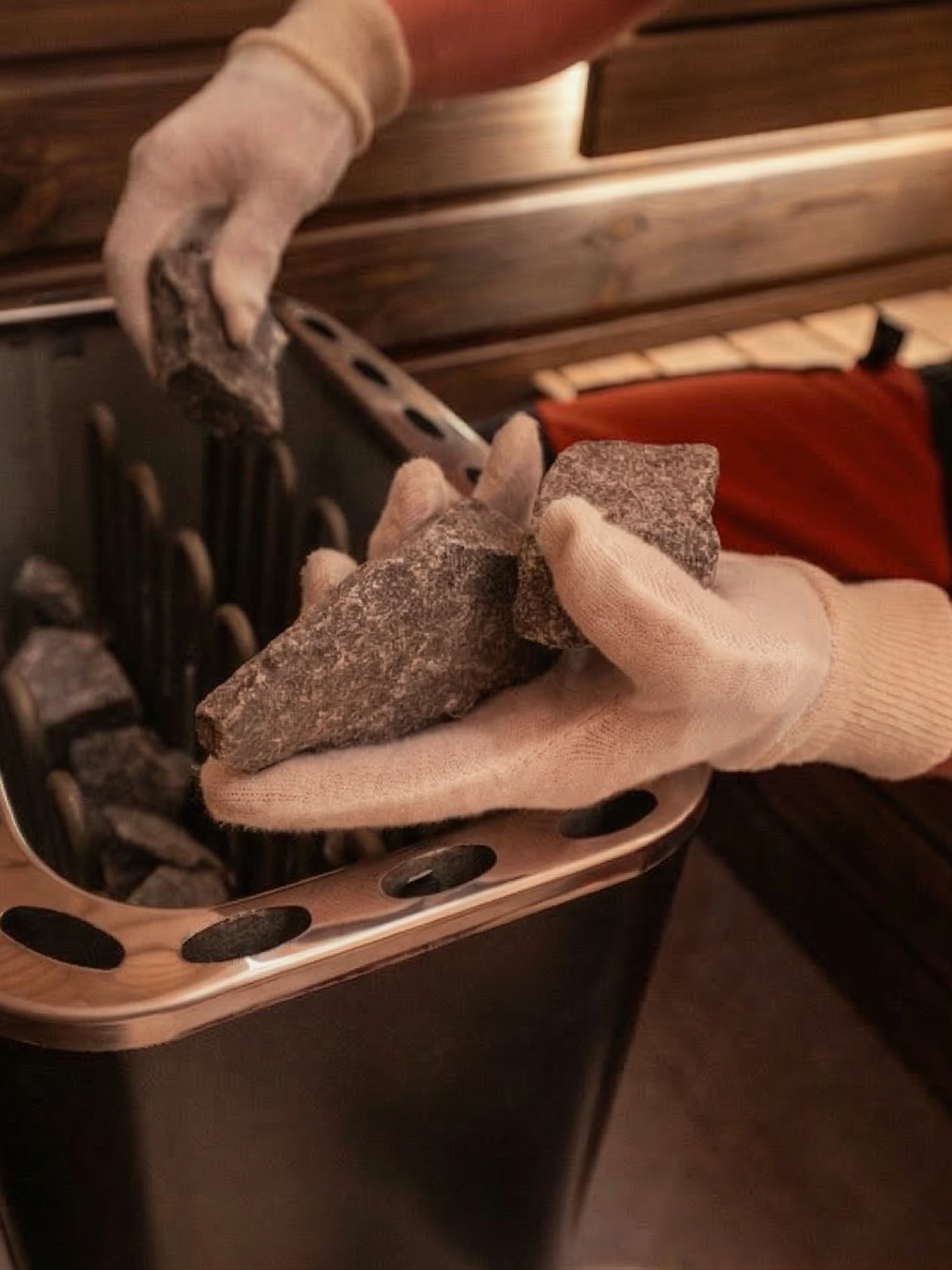 Person wearing gloves cleaning a grill with a brush and scrubber.