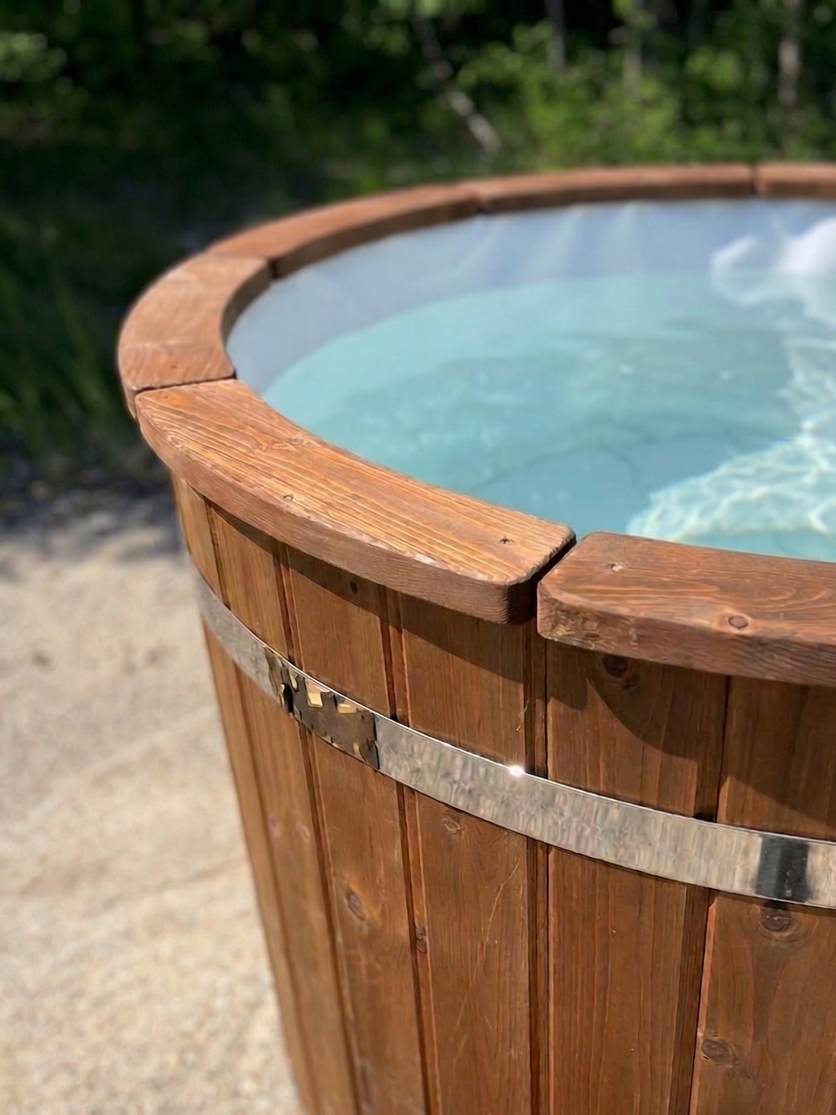 Wooden hot tub with clear water in a natural setting