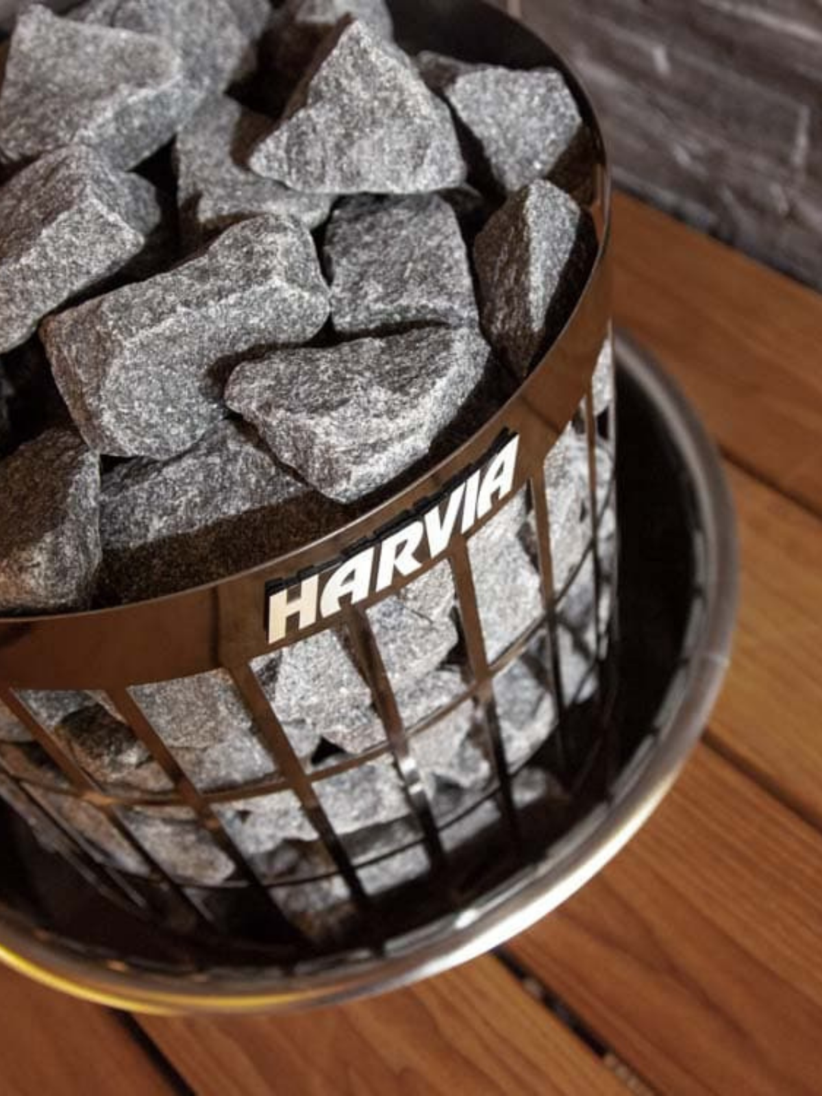 Harvia branded container filled with small stones on a wooden surface.
