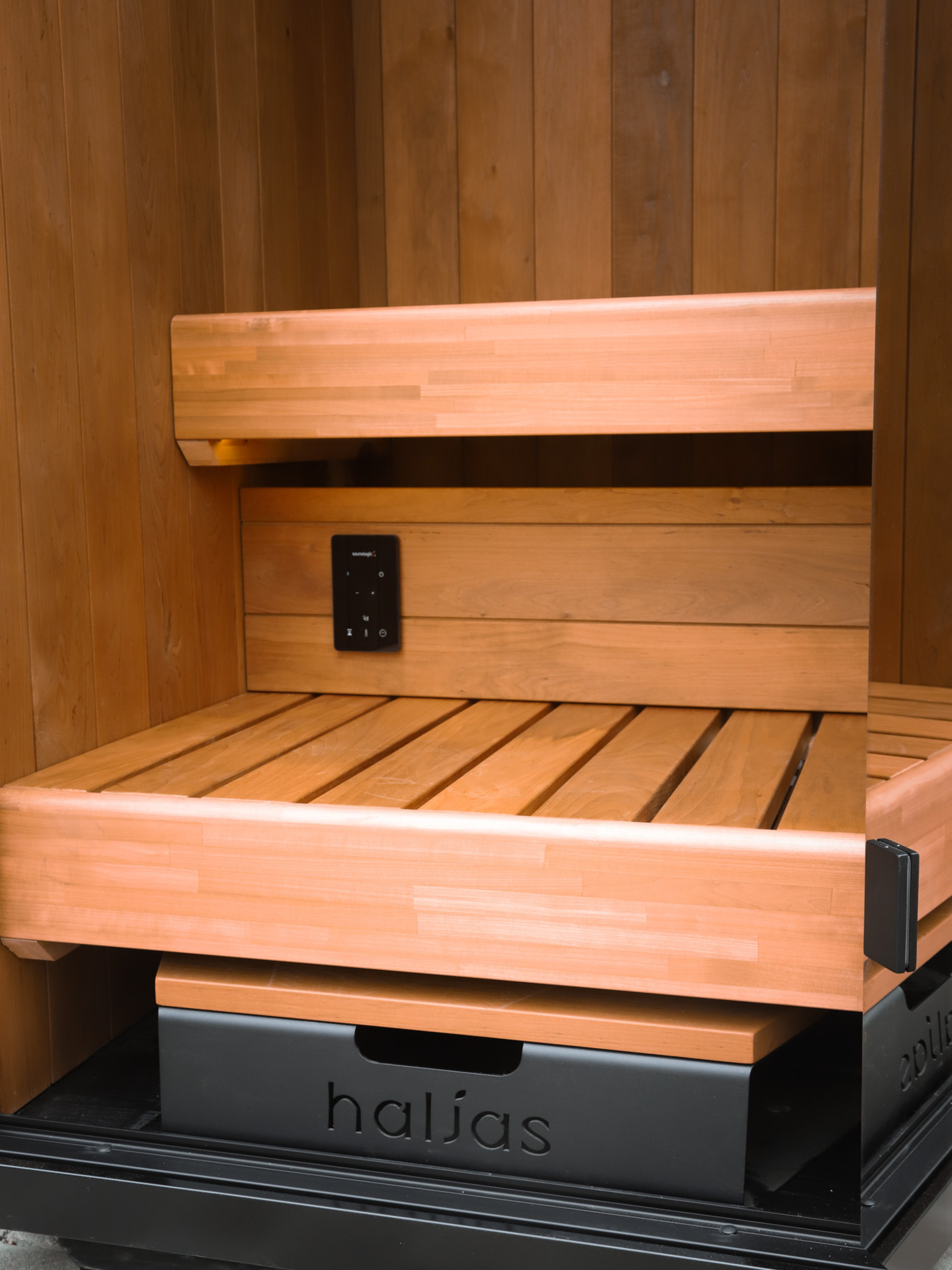Wooden sauna seat with 'halias' branding inside a wooden sauna enclosure.