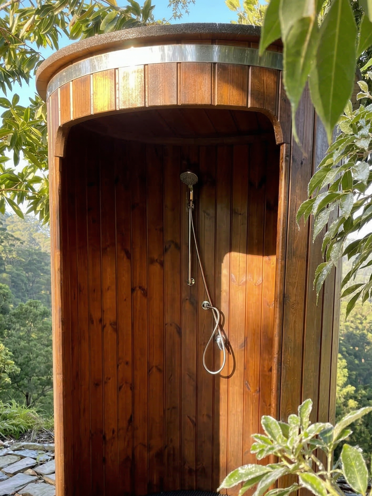 Wooden outdoor shower enclosure surrounded by greenery