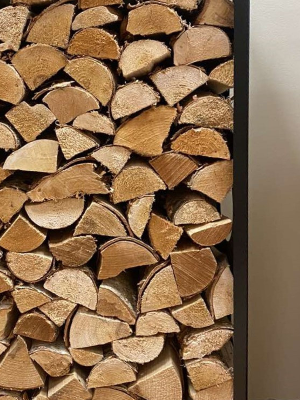 Stack of neatly arranged wooden logs against a neutral background