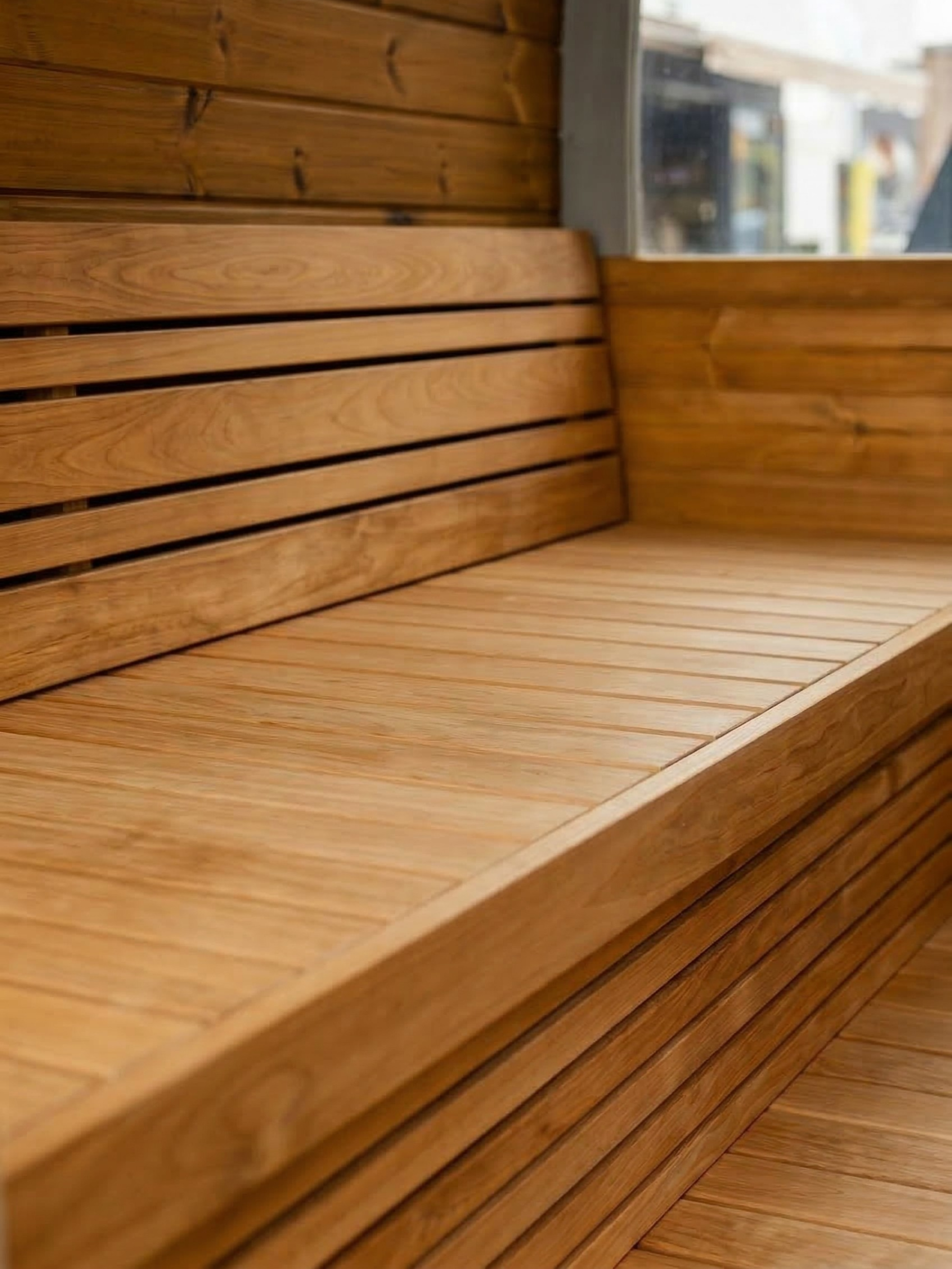 Close-up of a wooden bench with a blurred background