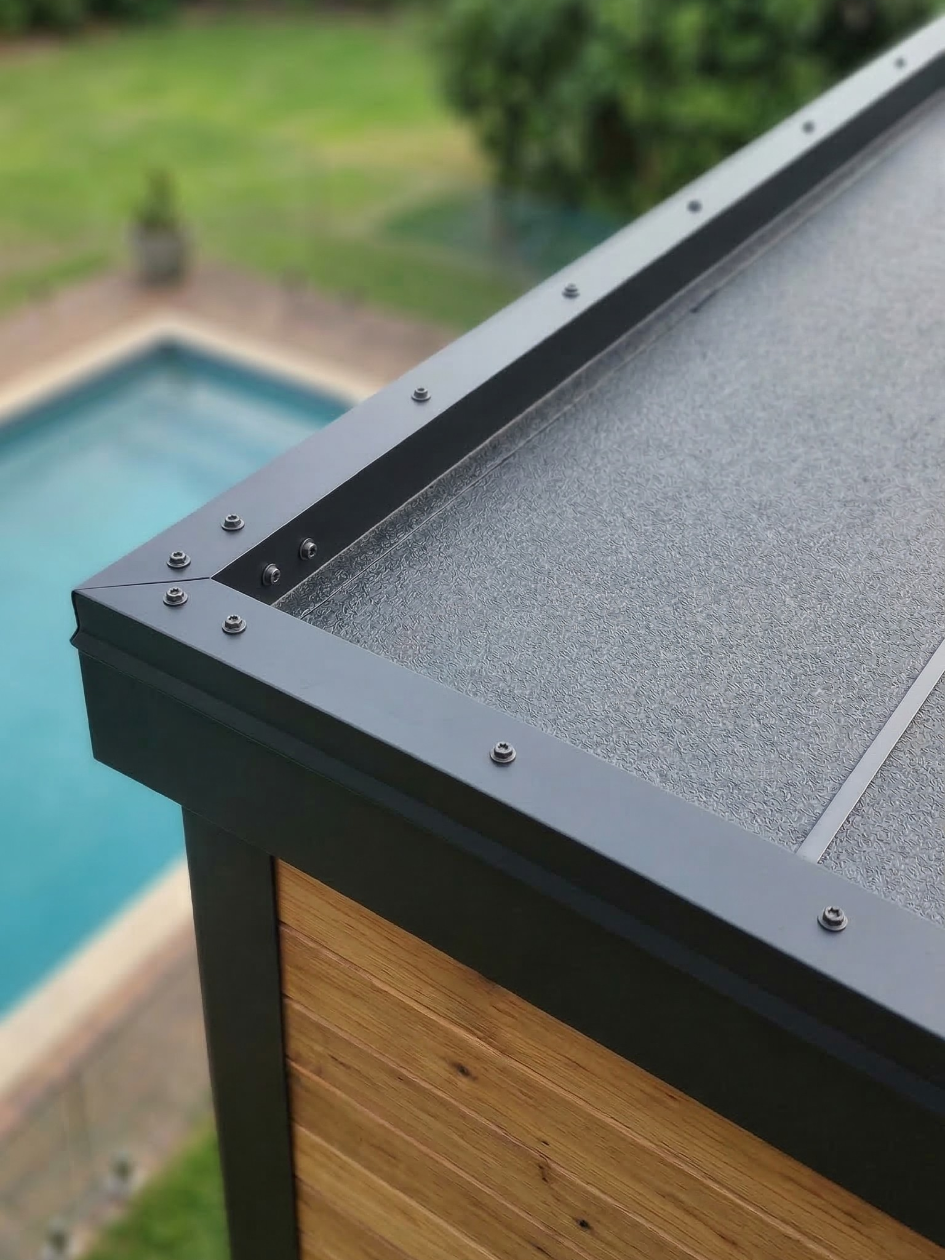 Close-up of a pool cover with a pool in the background