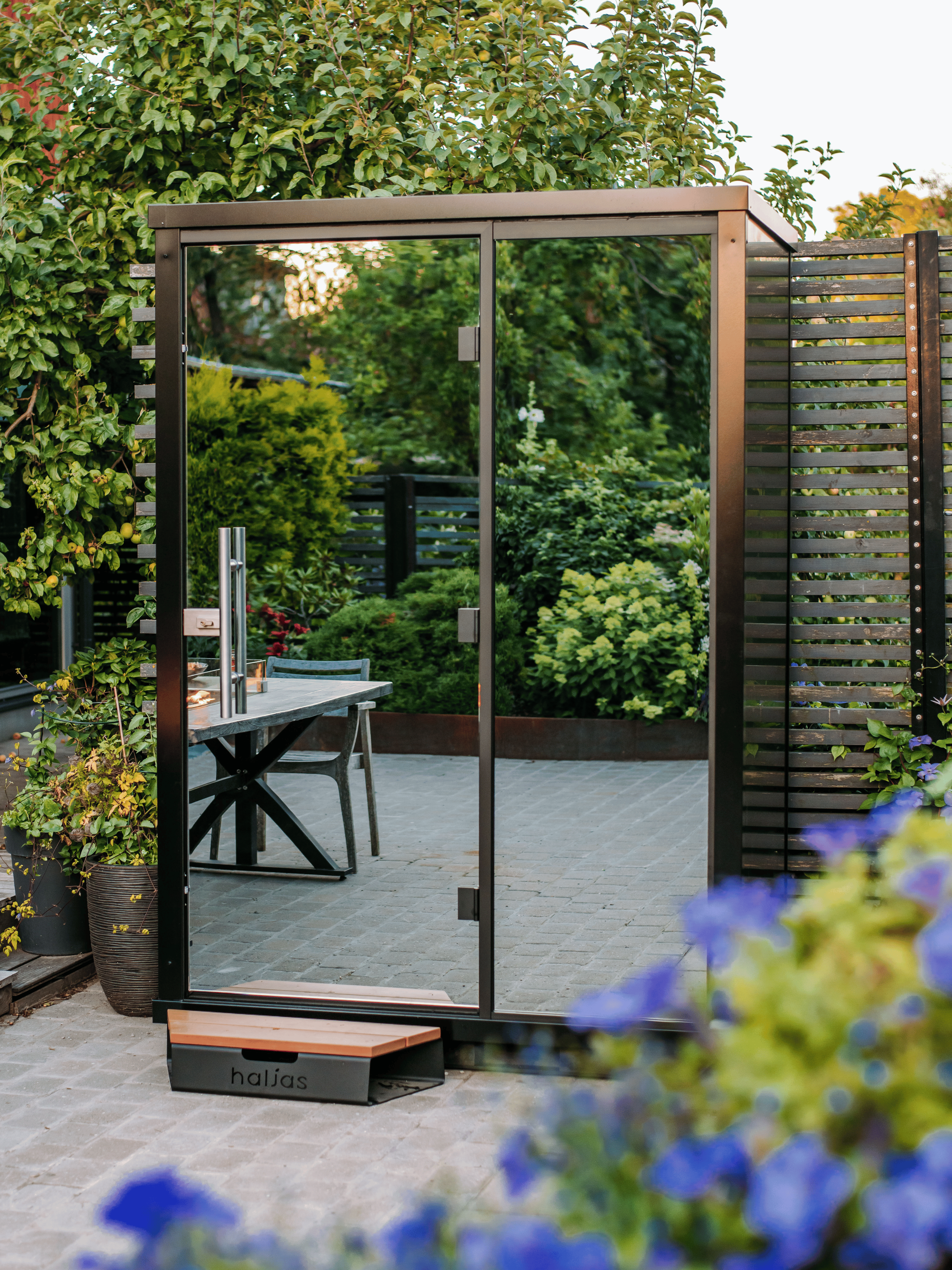 Modern outdoor shed with glass doors in a garden setting