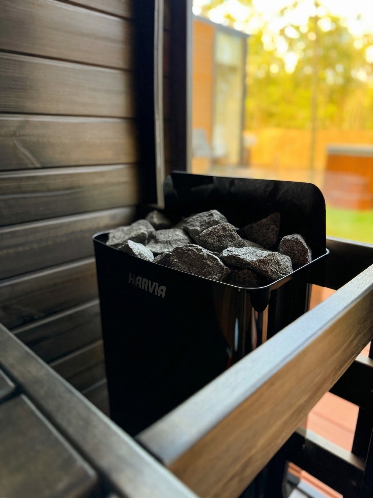 Harvia outdoor fireplace with rocks and wooden structure
