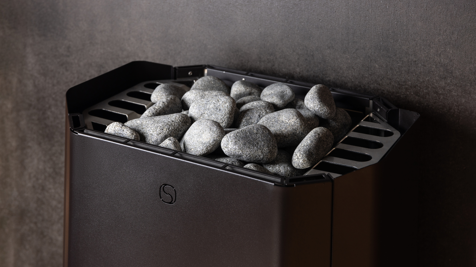 Black stone grill with stones inside on a dark background